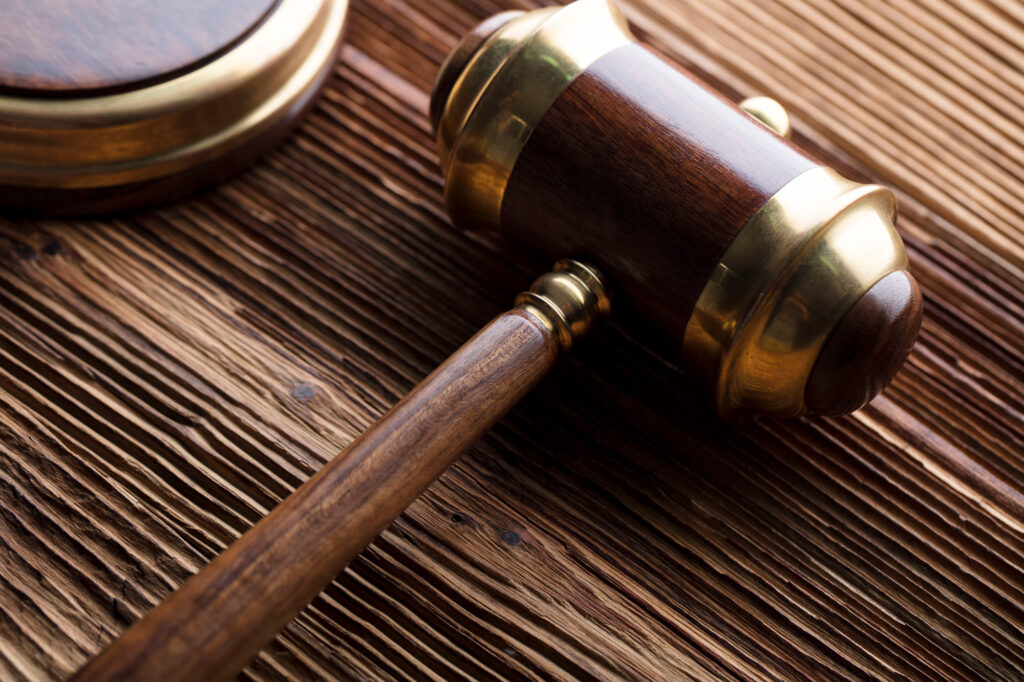 GFIについて 3 A close-up of a gavel on a wooden desk, representing the concept of food policy.